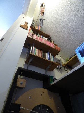 View from floor level looking up, showing the home dumbbell against the wall, with rope heading up through holes in shelving to pulleys and back down to the sally.